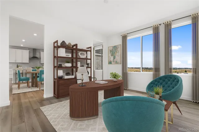 a living room with furniture a large window and wooden floor