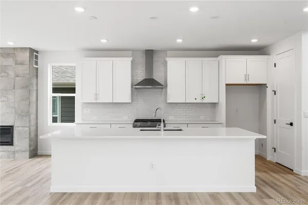 a kitchen with kitchen island sink stove and cabinets