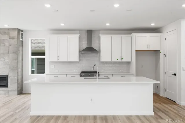 a kitchen with kitchen island sink stove and cabinets