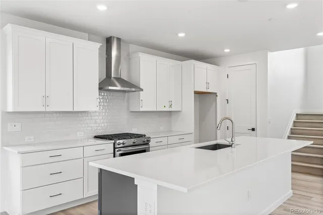 a kitchen with stainless steel appliances white cabinets and a sink