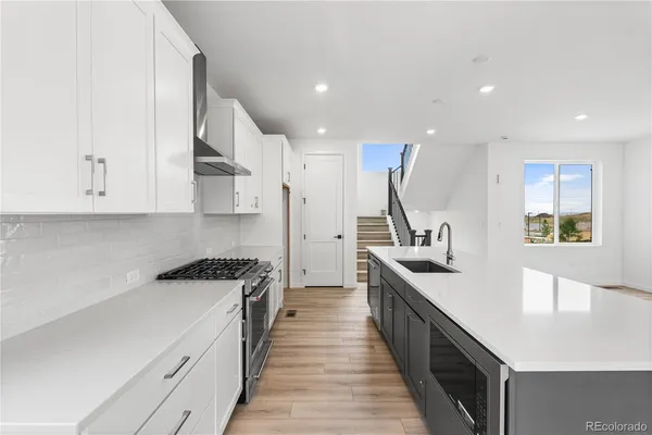a kitchen with white cabinets and appliances