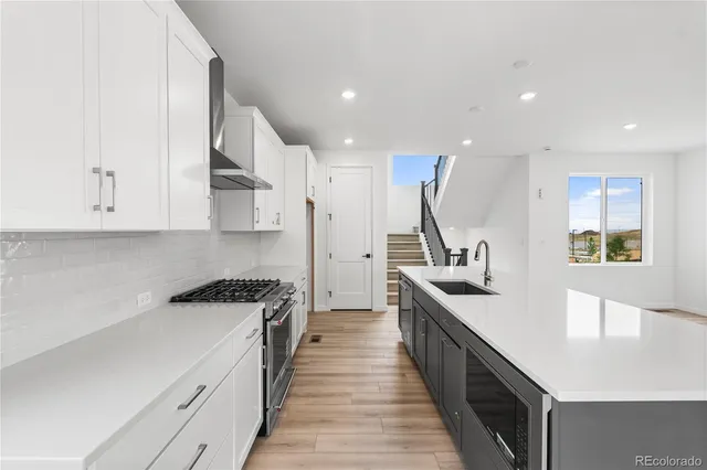 a kitchen with white cabinets and appliances