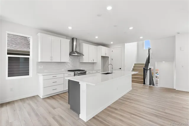 a large kitchen with stainless steel appliances kitchen island granite countertop a stove a sink and a refrigerator