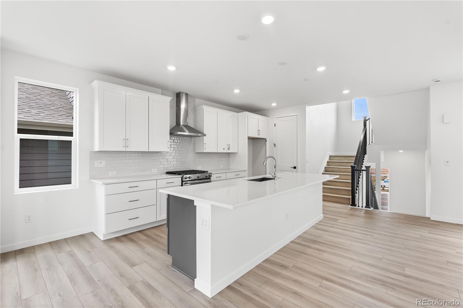 11972 Octave Avenue Lone Tree, CO 80134 - Photo 8 of 31 a large kitchen with stainless steel appliances kitchen island granite countertop a stove a sink and a refrigerator