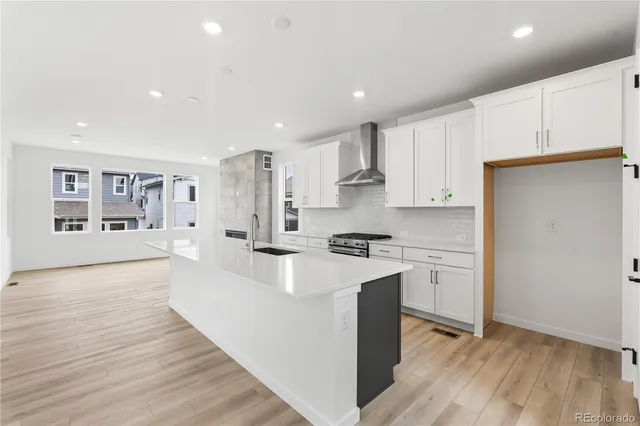 a large kitchen with stainless steel appliances granite countertop a stove a sink and a refrigerator