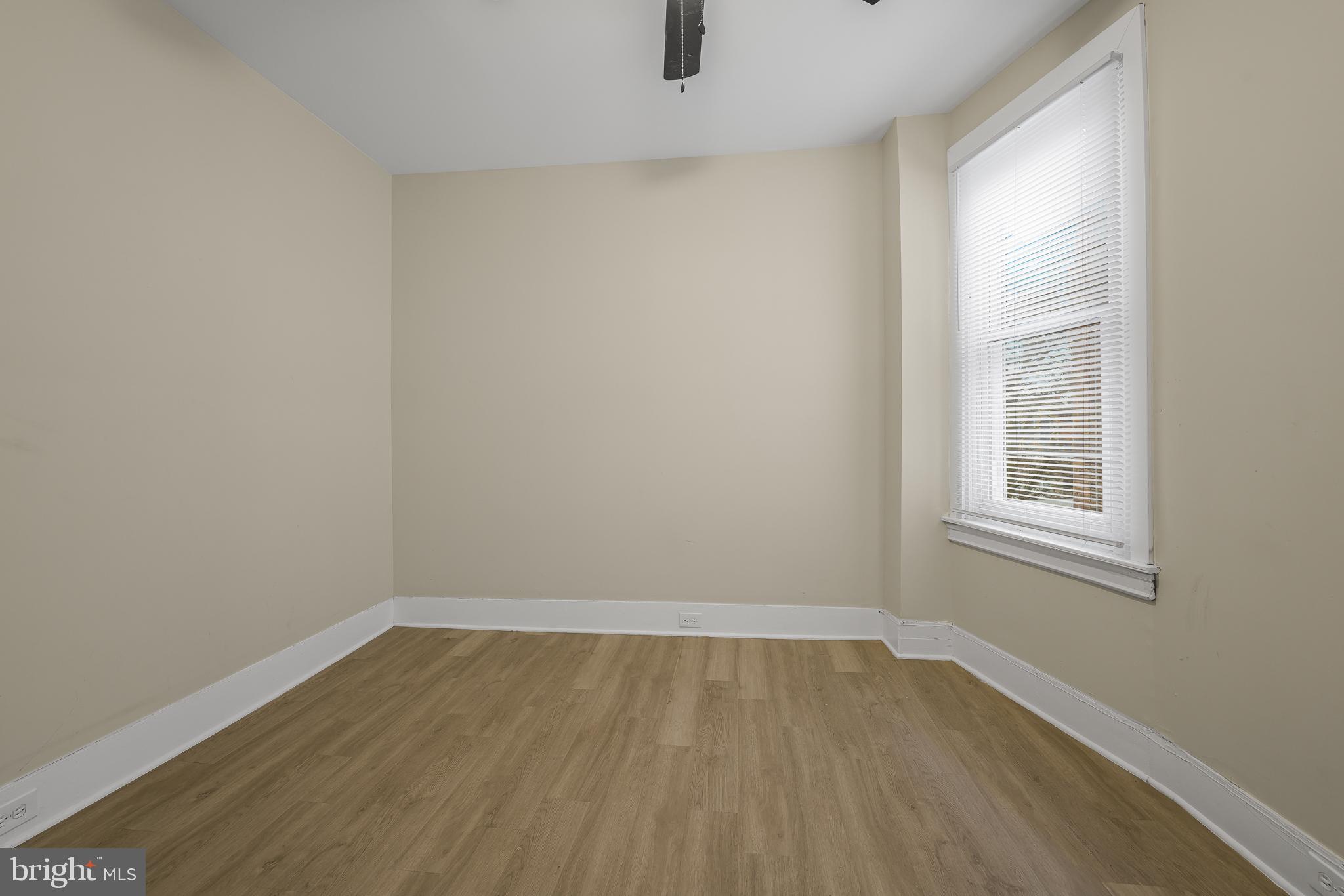 5723 Spruce Street, Unit 2 Philadelphia, PA 19139 - Photo 14 of 16 an empty room with wooden floor and windows