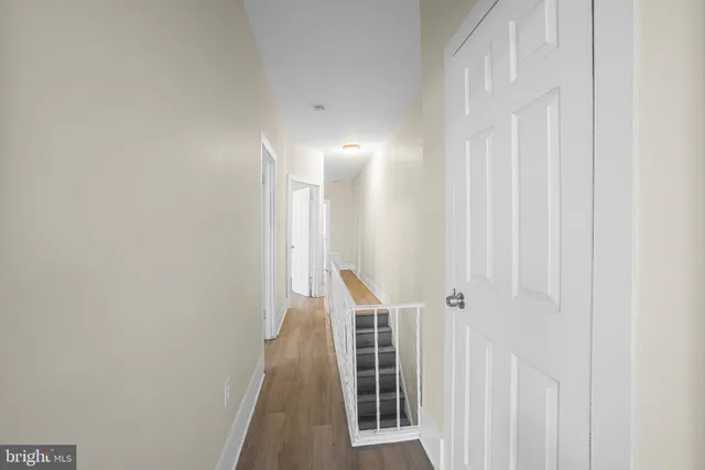 a view of a hallway with wooden floor and entryway