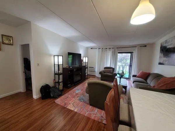 a living room with furniture a flat screen tv and kitchen view