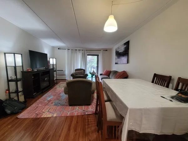 a living room with furniture a flat screen tv and kitchen view