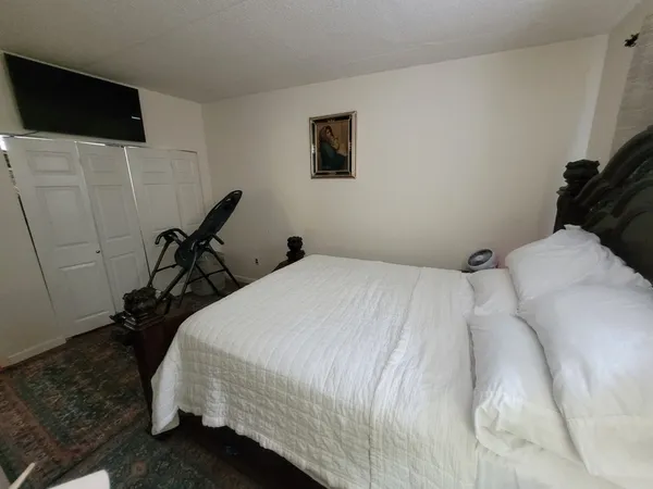 a bed room with a bed tv and a desk