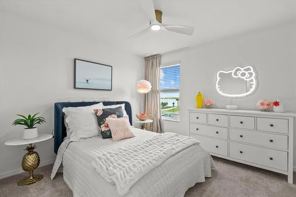 a view of a white house next to a yard with big trees