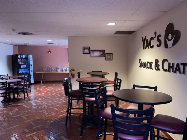 a kitchen with stainless steel appliances kitchen island granite countertop a refrigerator a stove a sink a dining table and chairs with wooden floor