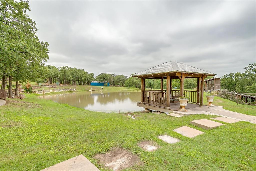 383 County Road 3672 Springtown, TX 76082 - Photo 2 of 39 Area featuring a gazebo, a water view, a yard, view of wooded area, and a patio