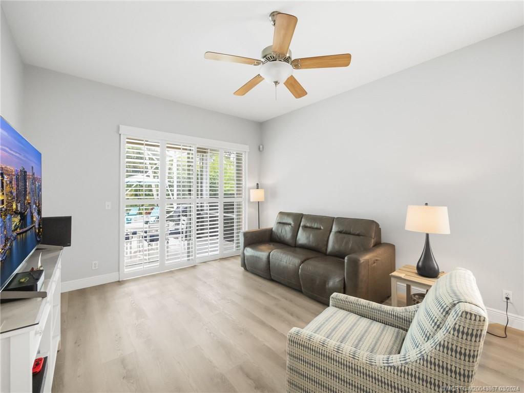 2432 Southeast Springtree Place Stuart, FL 34997 - Photo 12 of 24 a living room with furniture a ceiling fan and a flat screen tv