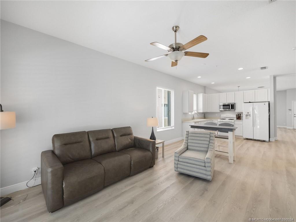 2432 Southeast Springtree Place Stuart, FL 34997 - Photo 13 of 24 a living room with furniture and kitchen view