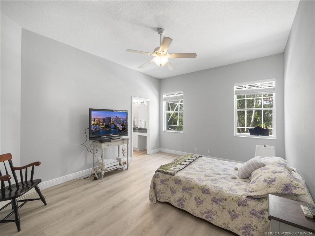 2432 Southeast Springtree Place Stuart, FL 34997 - Photo 14 of 24 a bedroom with bed tv and window