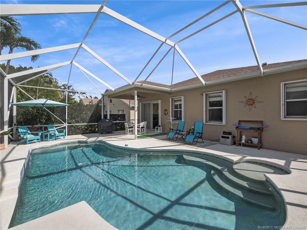 2432 Southeast Springtree Place Stuart, FL 34997 - Photo 23 of 24 a view of a patio with table and chairs under an umbrella