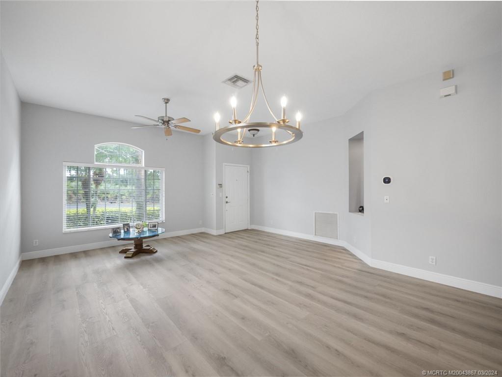 2432 Southeast Springtree Place Stuart, FL 34997 - Photo 8 of 24 a view of a room with window wooden floor and chandelier