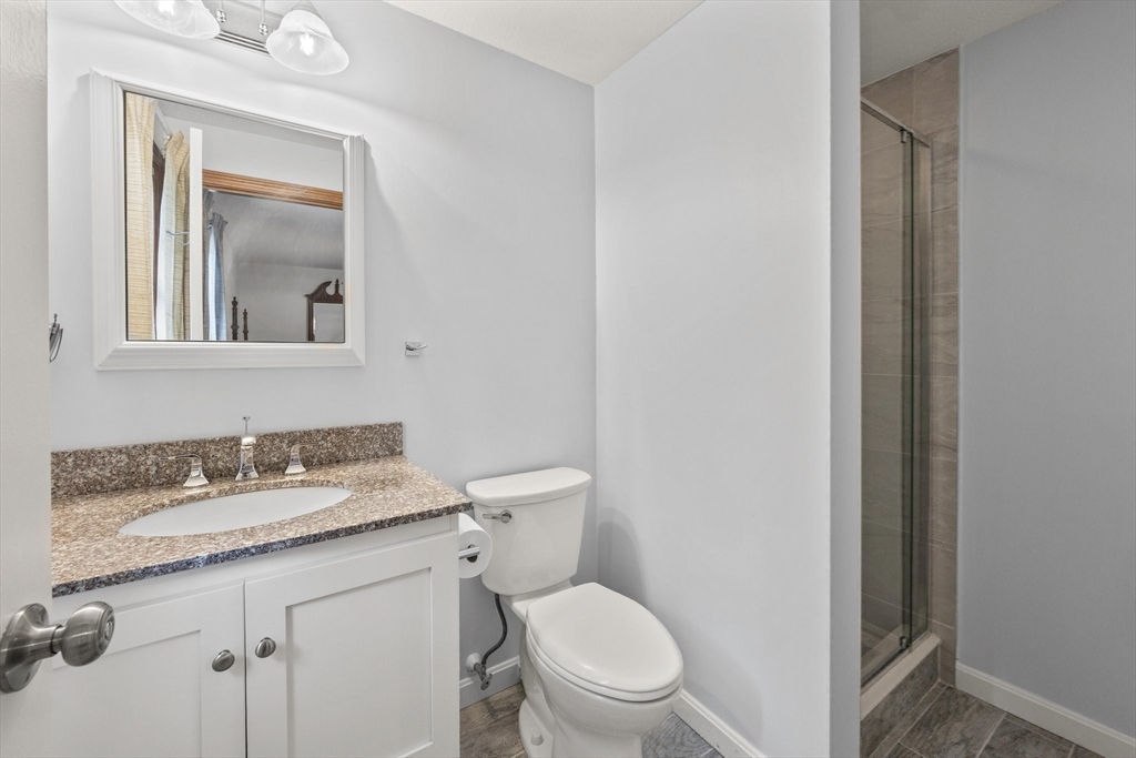 51 Poplar Drive Barnstable, MA 02655 - Photo 15 of 23 a bathroom with a granite countertop toilet sink and mirror