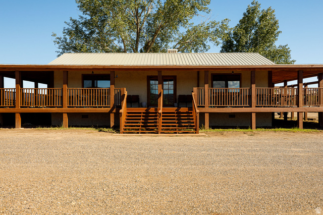View of front of house with crawl space, covered porch, and a metal roof