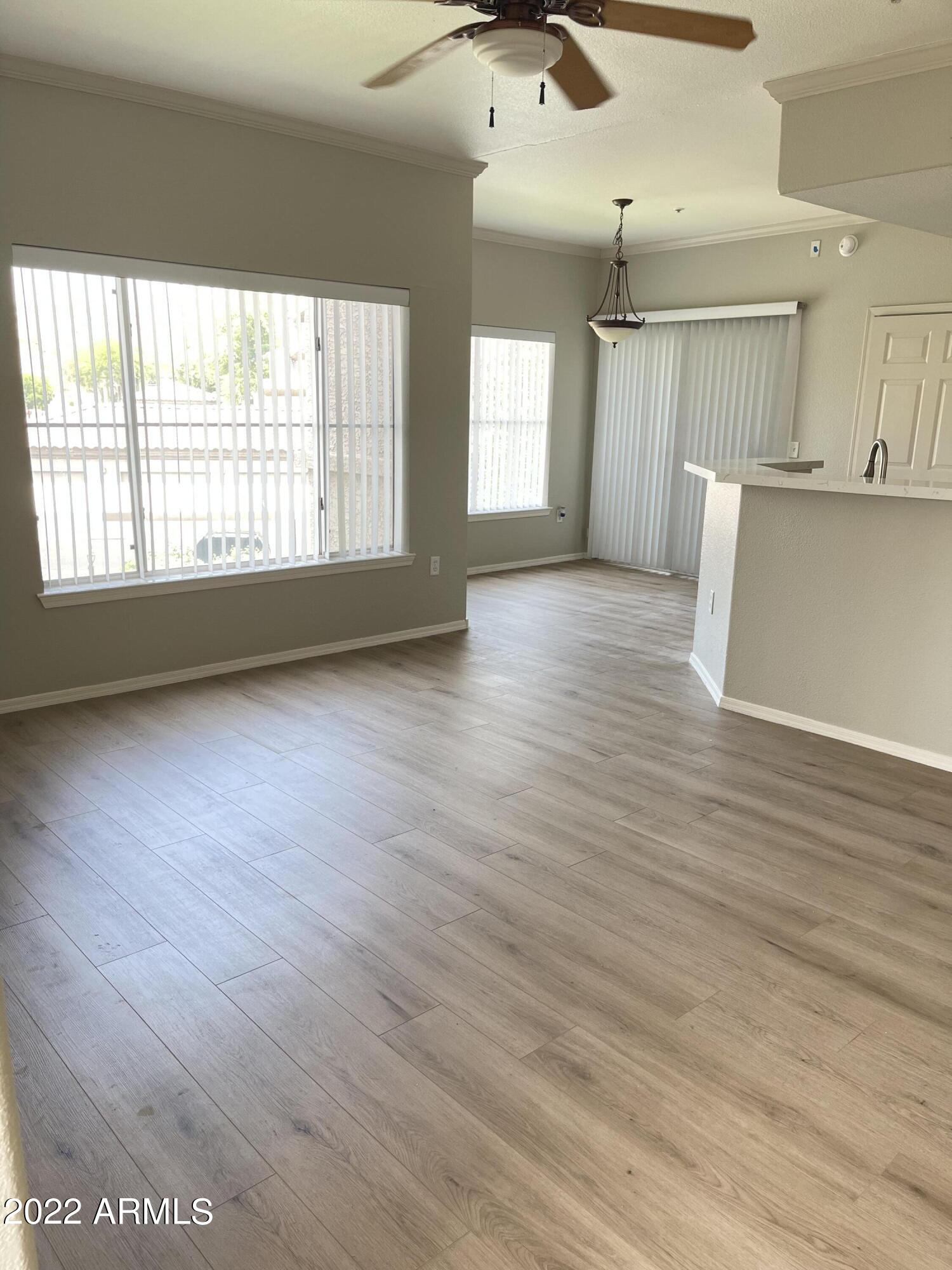 3236 East Chandler Boulevard, Unit 2093 Phoenix, AZ 85048 - Photo 13 of 28 a view of an empty room with wooden floor and a window