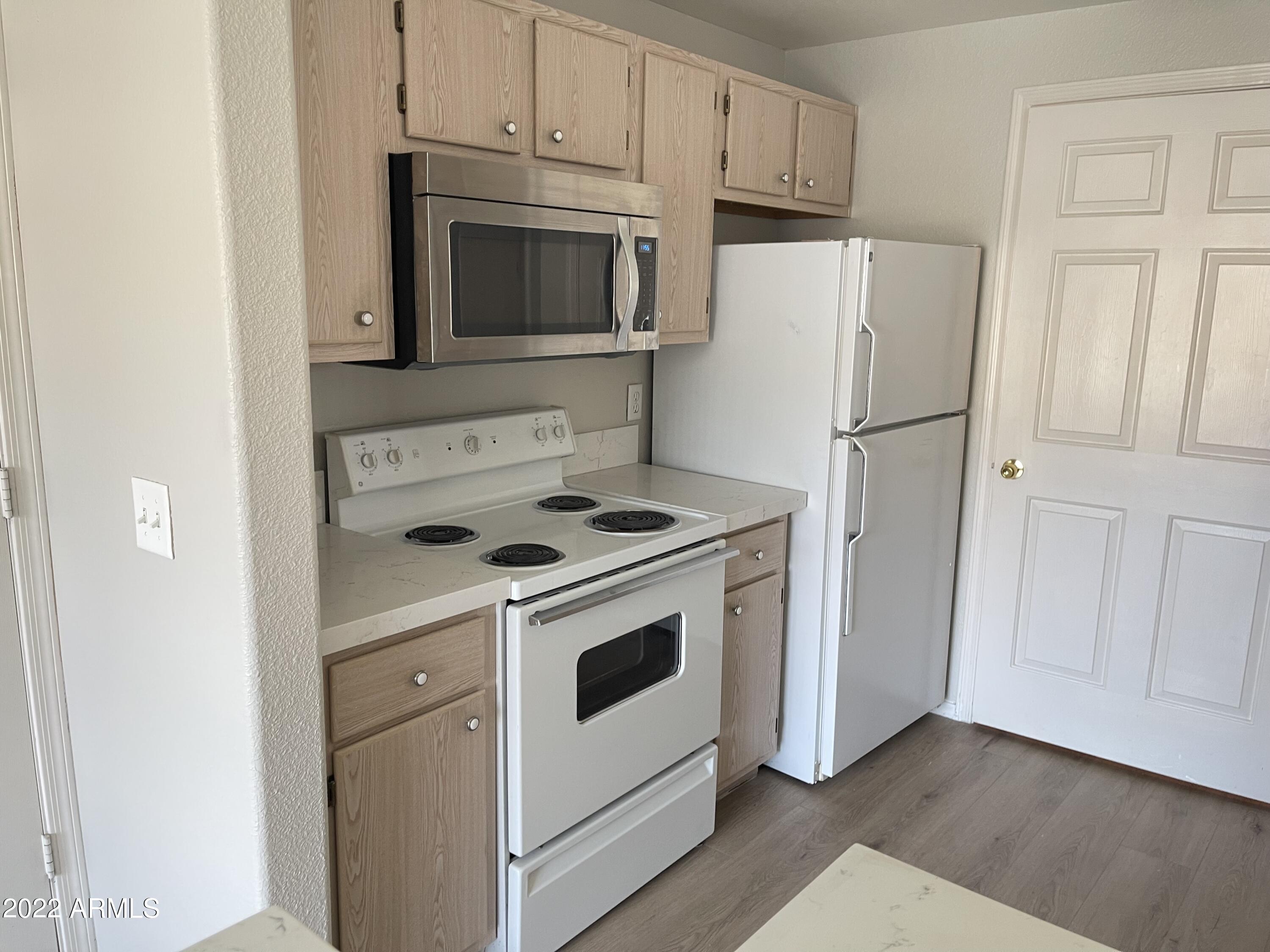 3236 East Chandler Boulevard, Unit 2093 Phoenix, AZ 85048 - Photo 6 of 28 a kitchen with a stove microwave and refrigerator