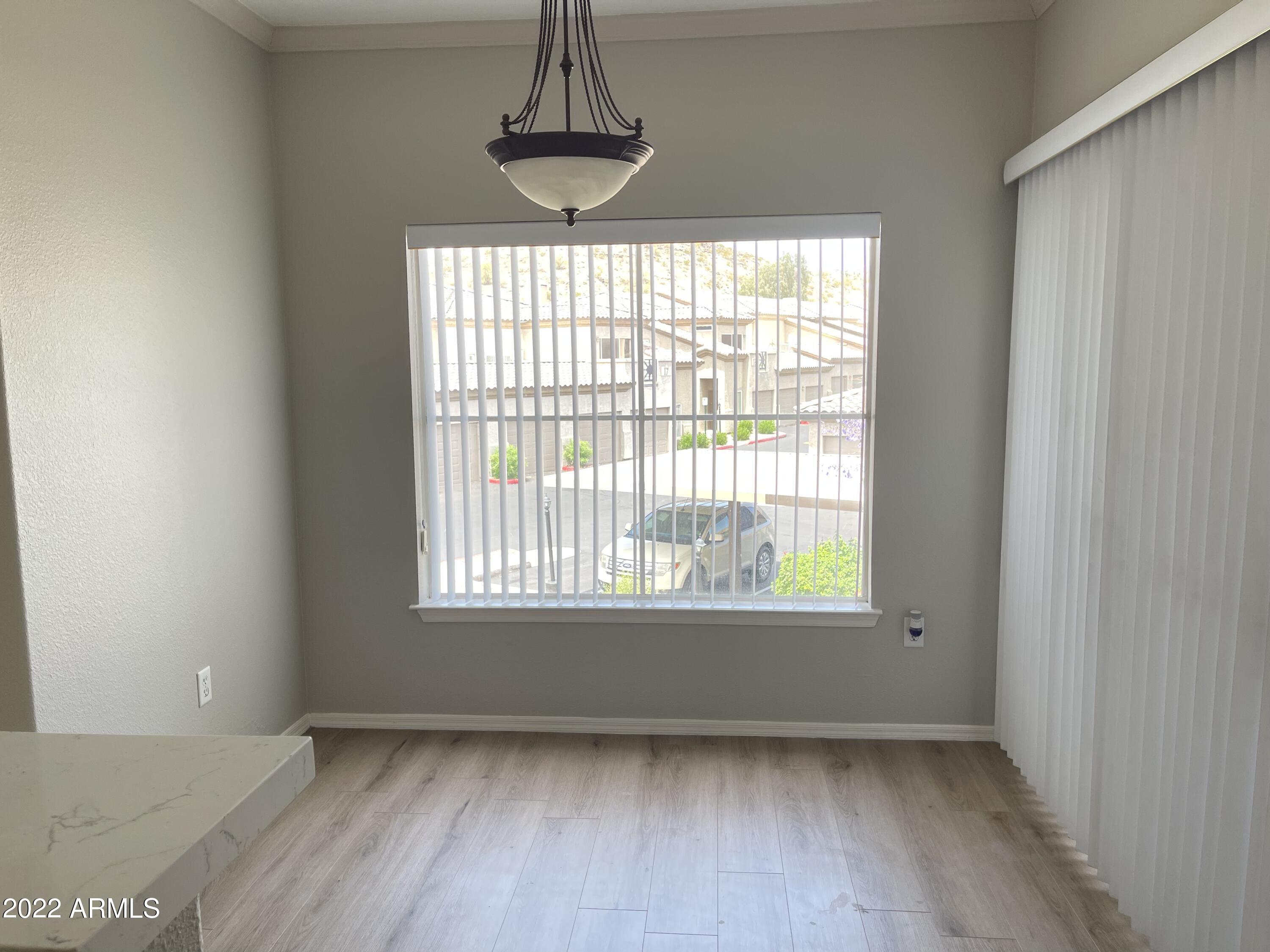 3236 East Chandler Boulevard, Unit 2093 Phoenix, AZ 85048 - Photo 7 of 28 a view of an empty room with chandelier and window