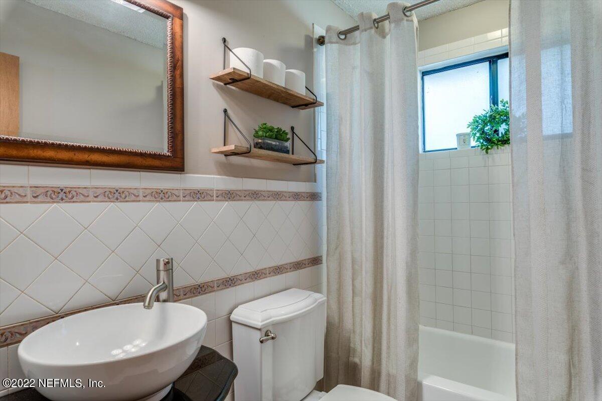 2124 Rothbury Drive Jacksonville, FL 32221 - Photo 18 of 27 a bathroom with a toilet a sink and mirror
