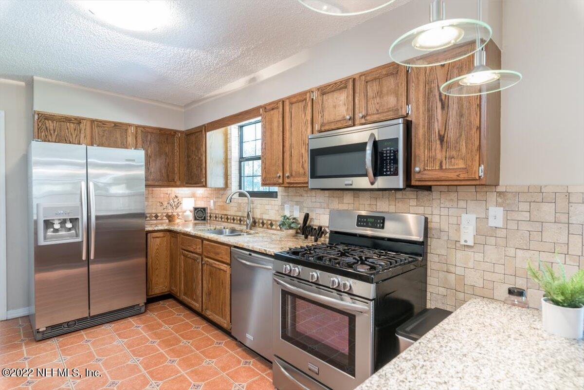 2124 Rothbury Drive Jacksonville, FL 32221 - Photo 8 of 27 a kitchen with stainless steel appliances granite countertop a stove a sink dishwasher a refrigerator and a microwave