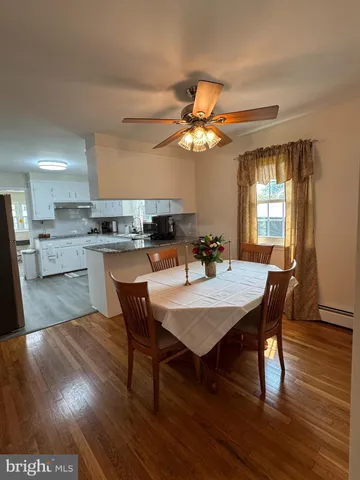 a view of kitchen with wooden floor and cabinets