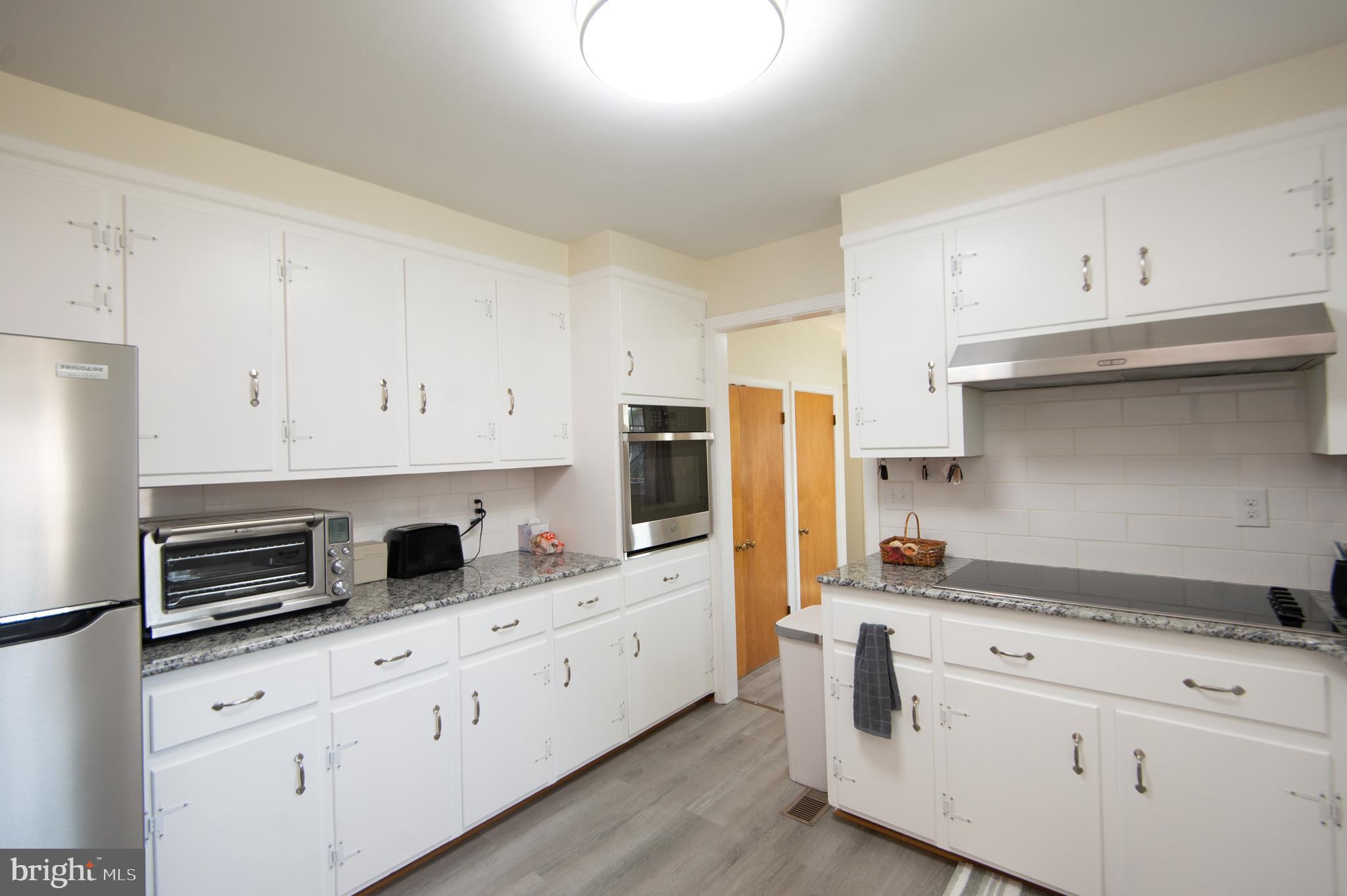8 West Liberty Street Ridgely, MD 21660 - Photo 10 of 55 a kitchen with granite countertop white cabinets and stainless steel appliances