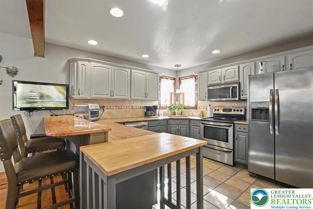 118 Hollow Drive Stroudsburg, PA 18360 - Photo 12 of 45 a kitchen with stainless steel appliances granite countertop a sink a stove a refrigerator cabinets and chairs