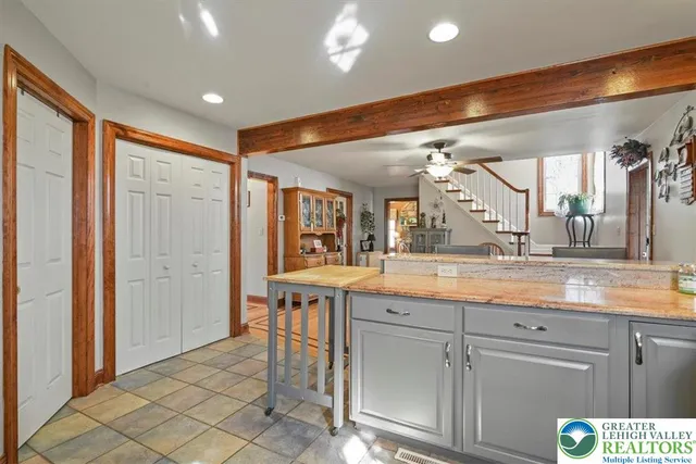 a large kitchen with granite countertop a sink and cabinets