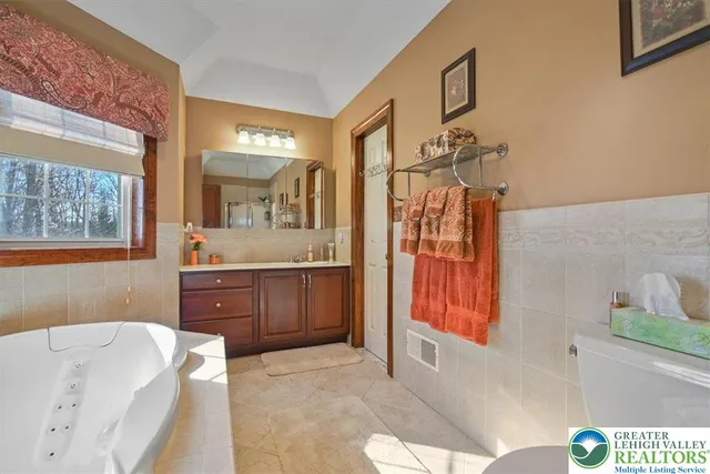 a bathroom with a tub sink and mirror