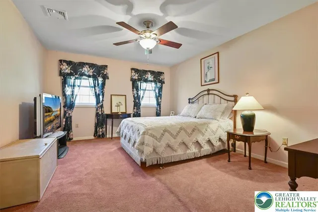 a spacious bedroom with a bed a dresser and potted plant