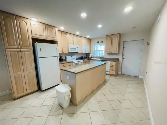 a kitchen with a refrigerator sink stove and cabinets