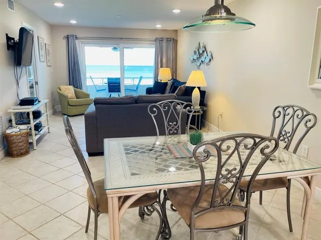 a view of a dining room with furniture a livingroom and chandelier