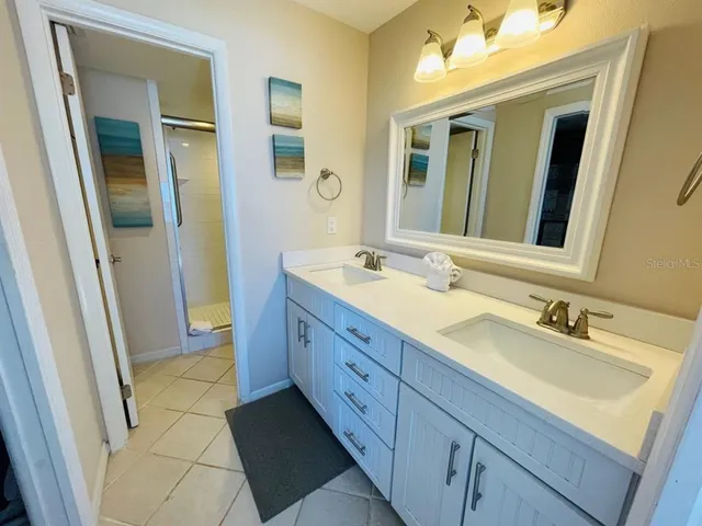a spacious bathroom with a double vanity sink and a mirror