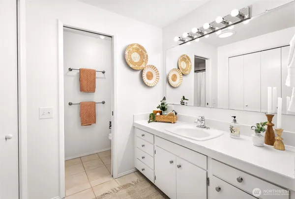 a bathroom with a sink and a clock on the wall