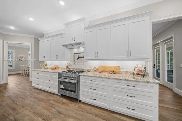 a kitchen with granite countertop white cabinets and white appliances
