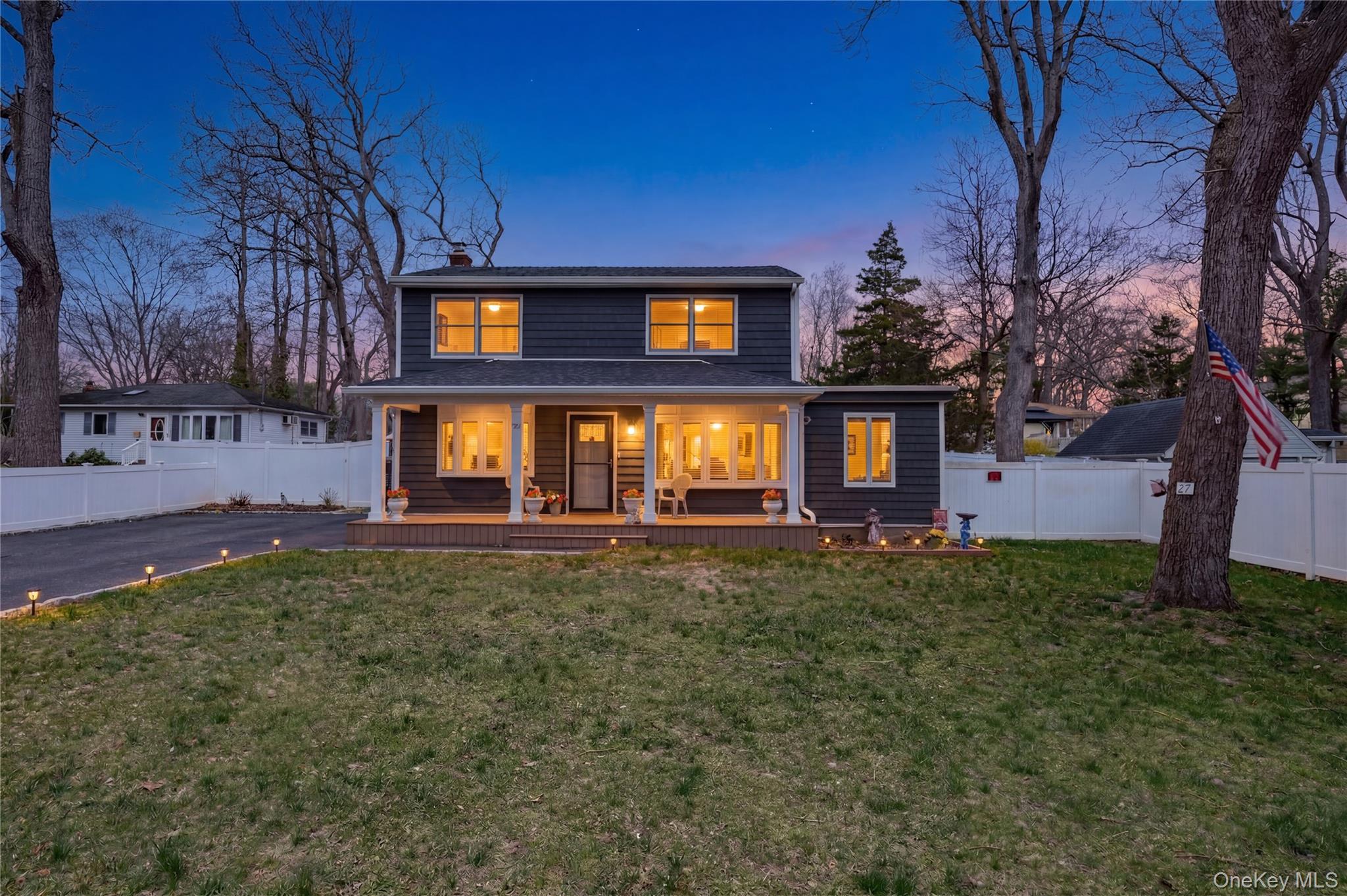 27 Half Mile Road Middle Island, NY 11953 - Photo 4 of 35 Twilight view of front of house featuring a fenced backyard, a chimney, and covered porch