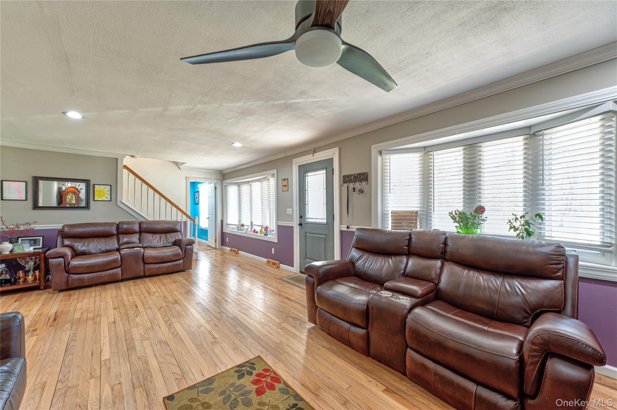 27 Half Mile Road Middle Island, NY 11953 - Photo 6 of 35 Living area with light wood-style flooring, ornamental molding, a ceiling fan, and a textured ceiling