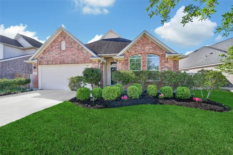 a front view of a house with a garden and plants