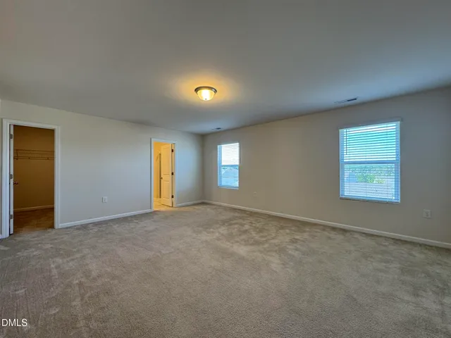 an empty room with a window and closet area