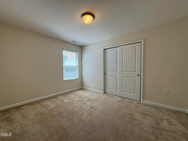 an empty room with windows and closet in it