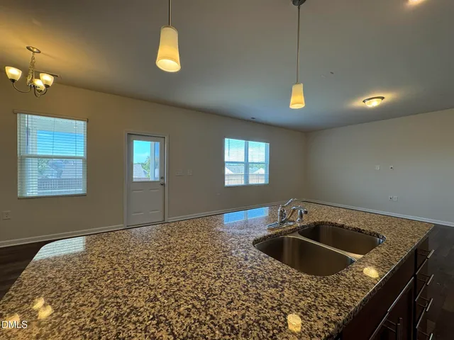 a kitchen with a sink a stove cabinets and a window