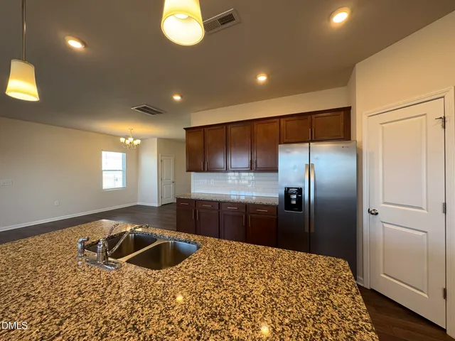 a kitchen with stainless steel appliances granite countertop a sink a stove and a refrigerator