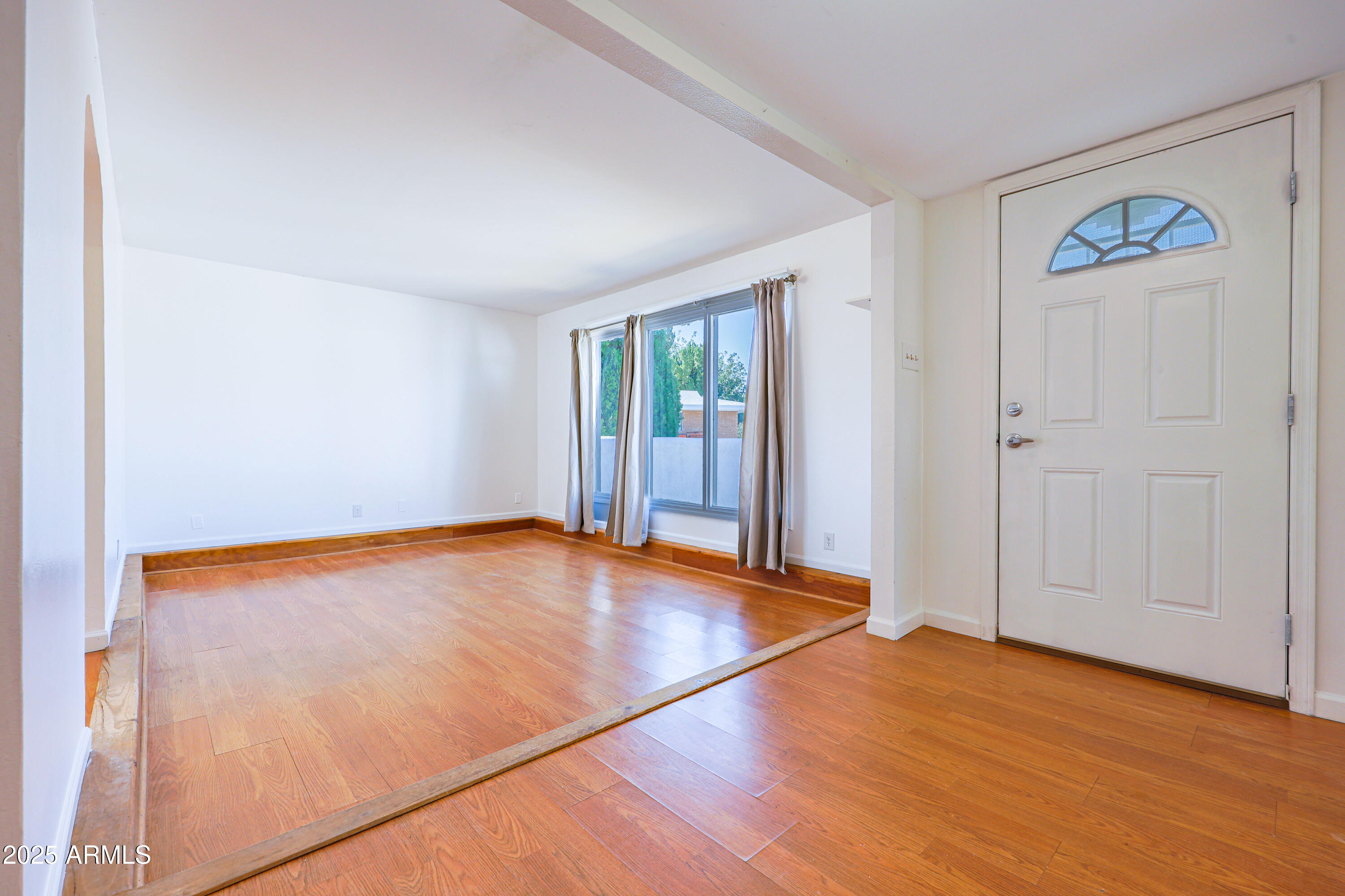 106 Neff Place Pearce, AZ 85625 - Photo 7 of 28 an empty room with wooden floor and windows