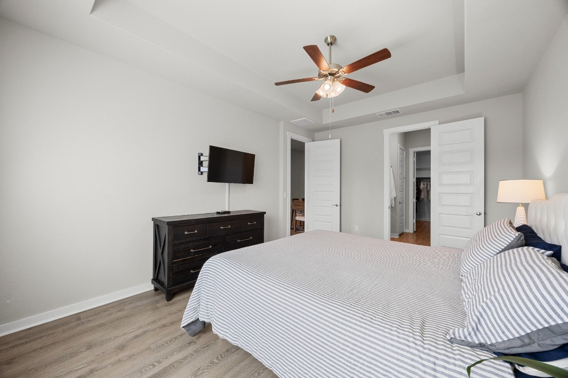 401 Peace Pipe Way Georgetown, TX 78628 - Photo 17 of 37 a bedroom with a bed and a chandelier