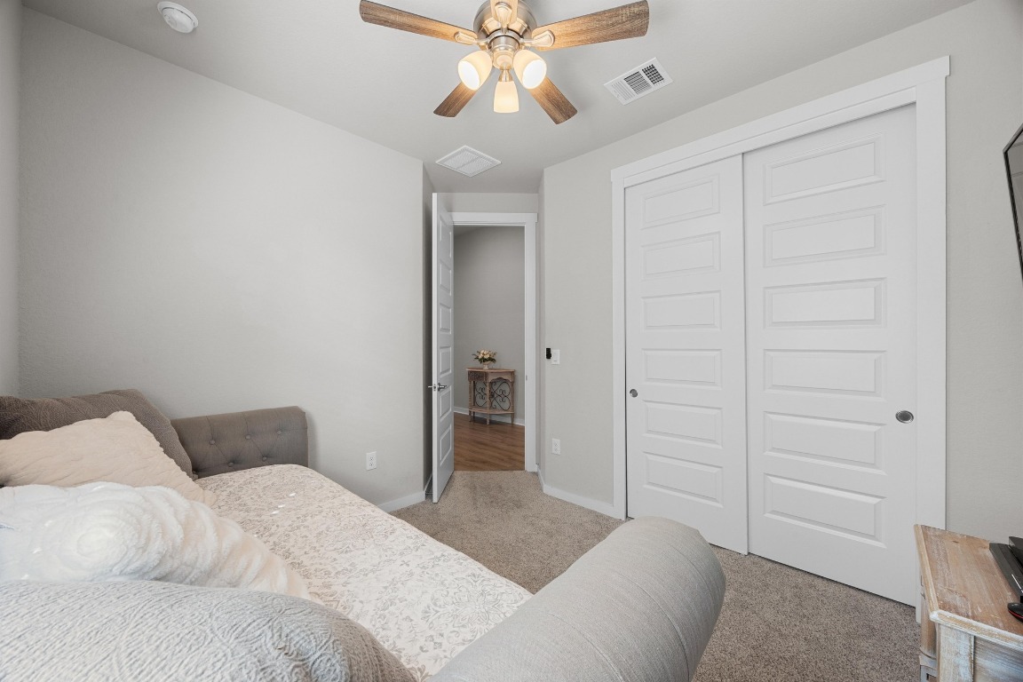 401 Peace Pipe Way Georgetown, TX 78628 - Photo 26 of 37 a bedroom with a bed and a chandelier